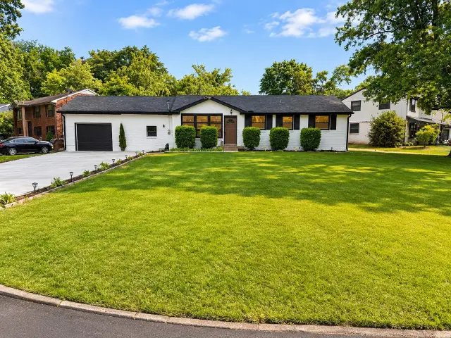 White brick ranch with manicured lawn